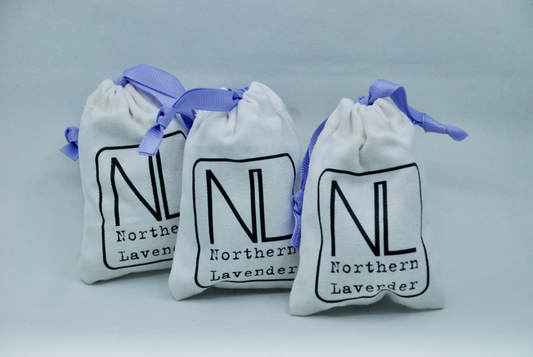 Three white drawstring bags with 'Northern Lavender' branding on a gray background